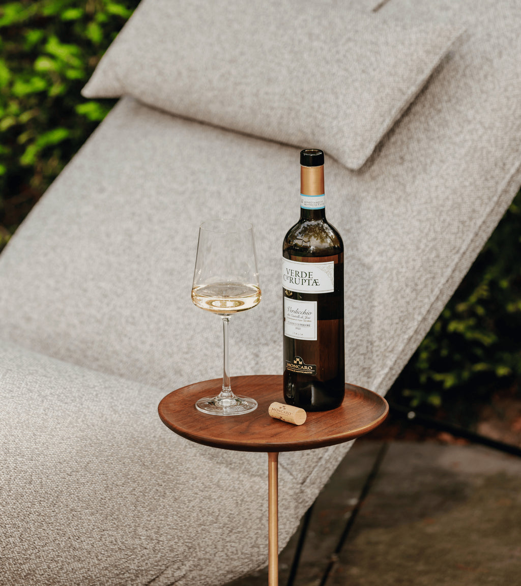 Lichtgrijze lounge stoel buiten van HoekbankXXL, met een zachte textuur en ontspannende stijl, op een terras met een drankje.
