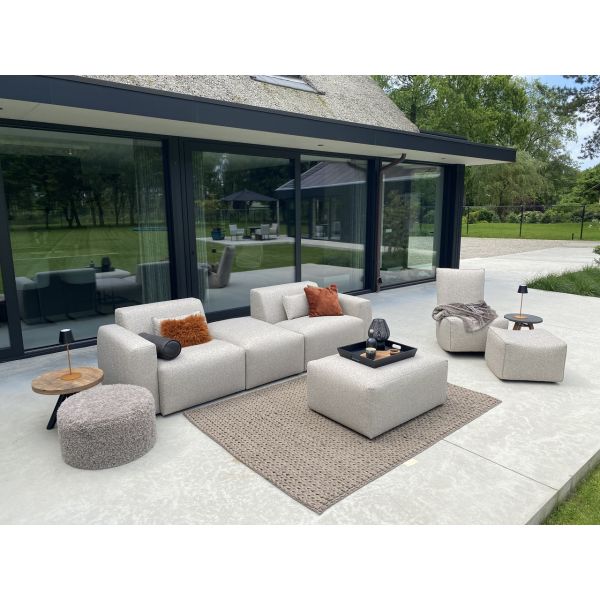 Grijze loungebank tuin Palma van HoekbankXXL, met losse kussens en een vierkante poef op een terras.
