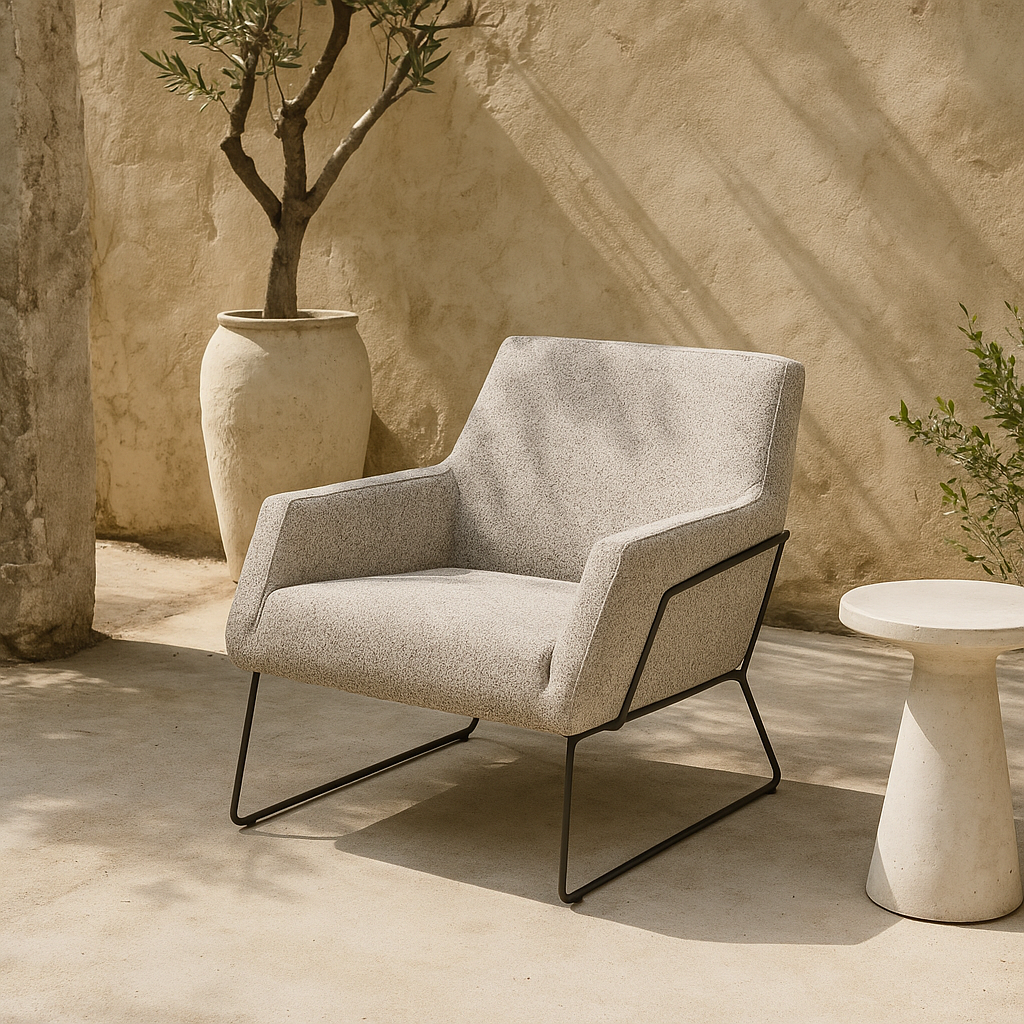 Outdoor fauteuil Rose van HoekbankXXL, met een licht gemêleerde stoffen bekleding en een zwart metalen frame, in een buitenomgeving.
