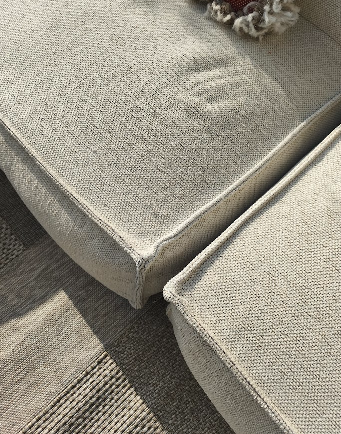 Beige loungebankset van HoekbankXXL, met grove textuur en strakke lijnen, deel van de zitting en een decoratief element.