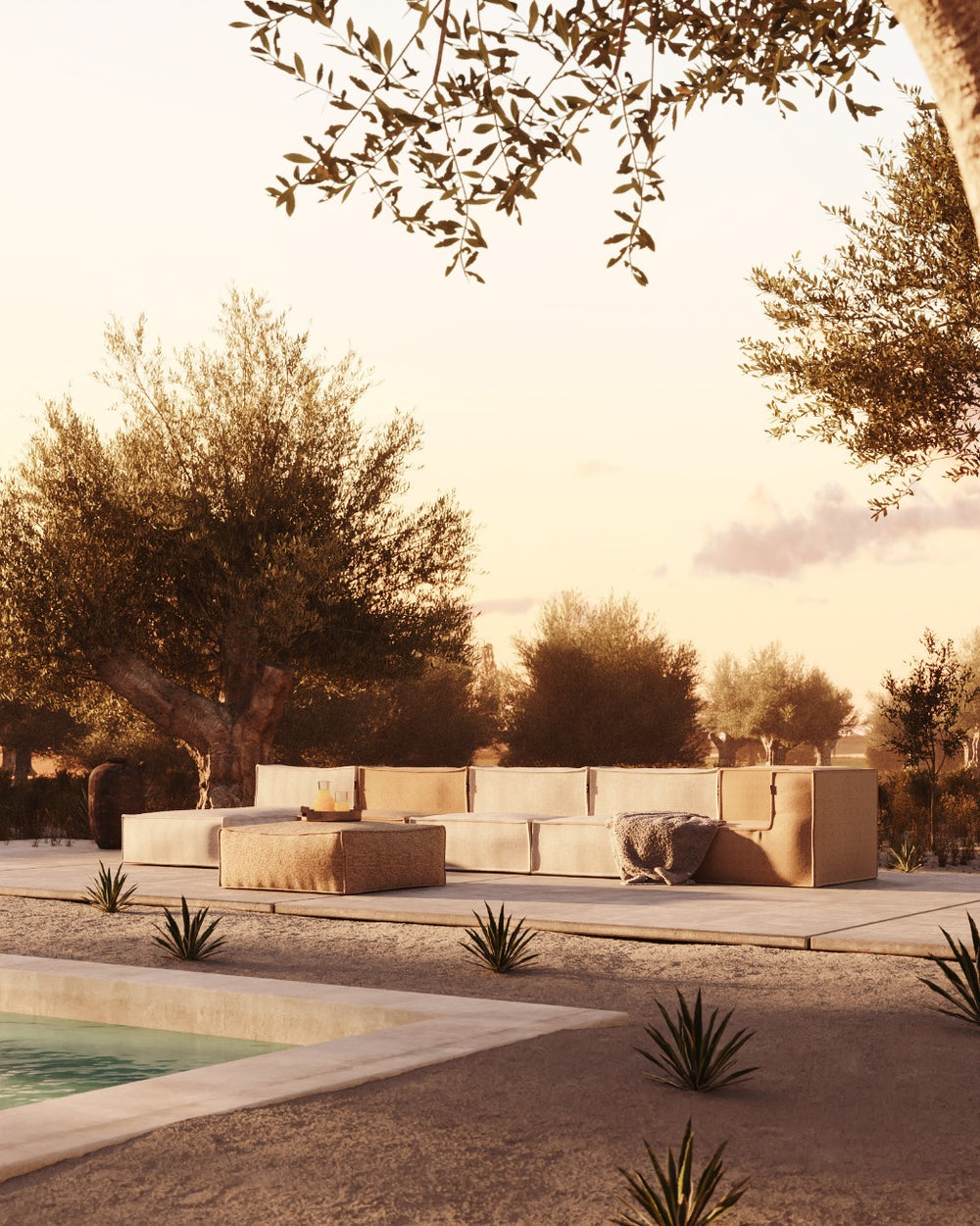 Zijdeachtige longchair loungestoel buiten van HoekbankXXL, geplaatst op een zonnig terras naast een zwembad en omgeven door groen.
